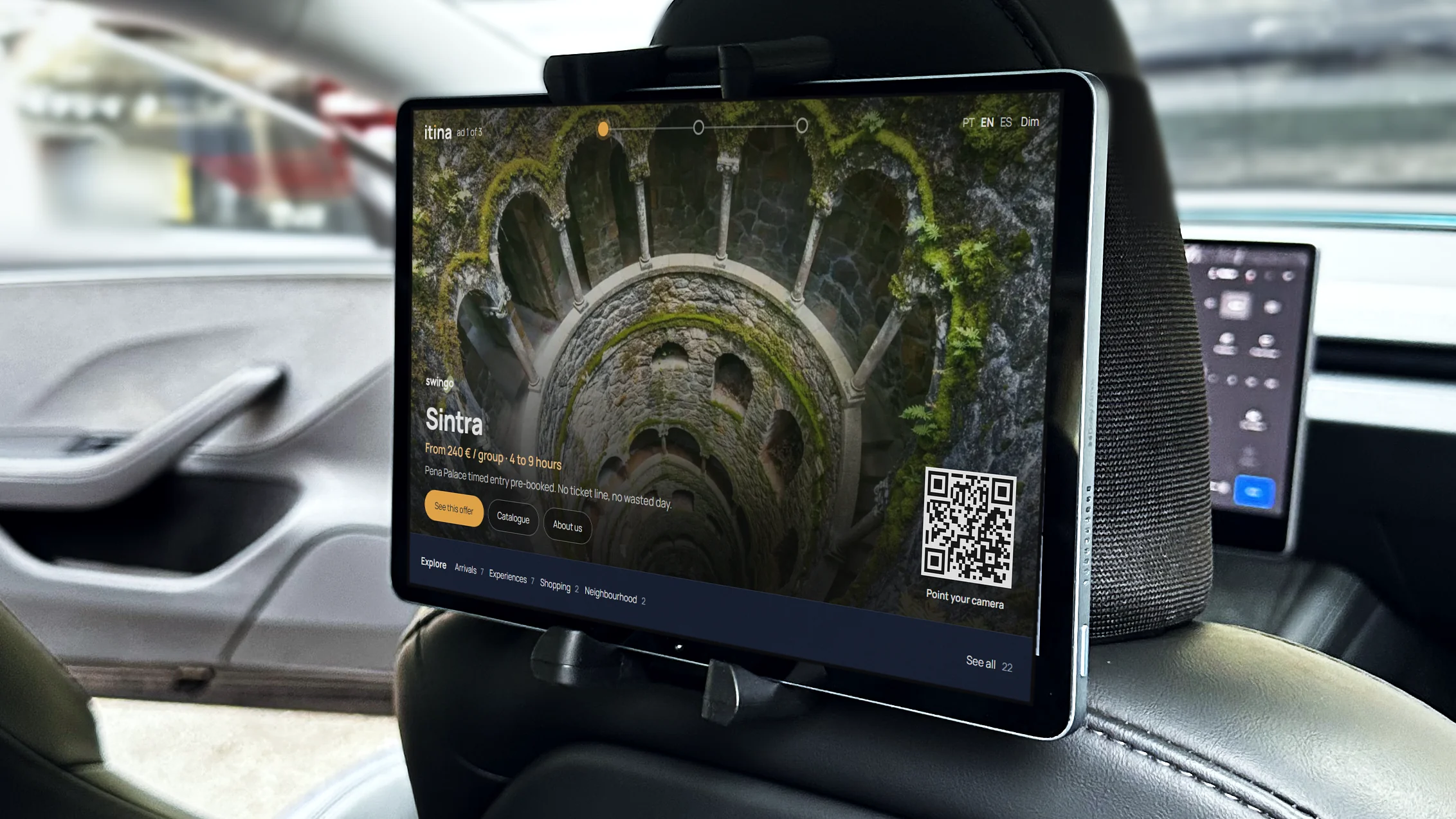 The tablet on the seatback of a fleet Tesla, showing a Sintra tour ad and the Explore bar